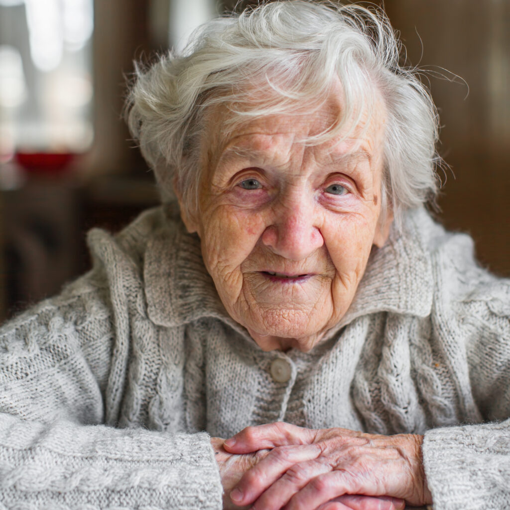 McArdle older woman with white hair leans forward