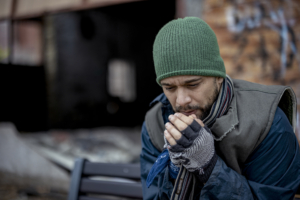 Homeless Man Warms His Hands on a Cold Day